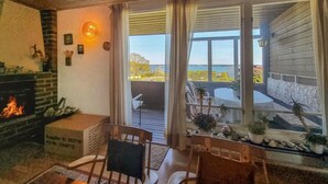Una habitación acogedora con chimenea, comedor y vistas al exterior.