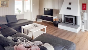 A modern living room with a grey sofa, a white coffee table, a TV, and a fireplace. - Stunning home in Tingsryd with WiFi (Tingsryd)