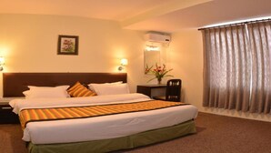 A hotel room with a large bed, two bedside lamps, a nightstand, a mirror, and a window with curtains. - MeroStay 167 Serenity (Kathmandu)
