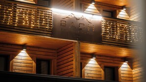 A wooden building with a sign reading "BACH Boutique Hotel." - Bach Boutique Hotel (Sappada)