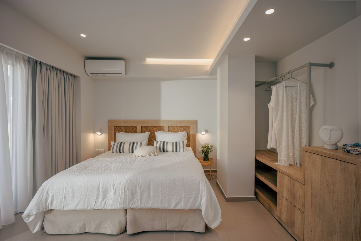 Ein modernes Schlafzimmer mit einem großen Bett, einem Holzkopfstück, Nachttischen mit Lampen und einer Holzkommode.