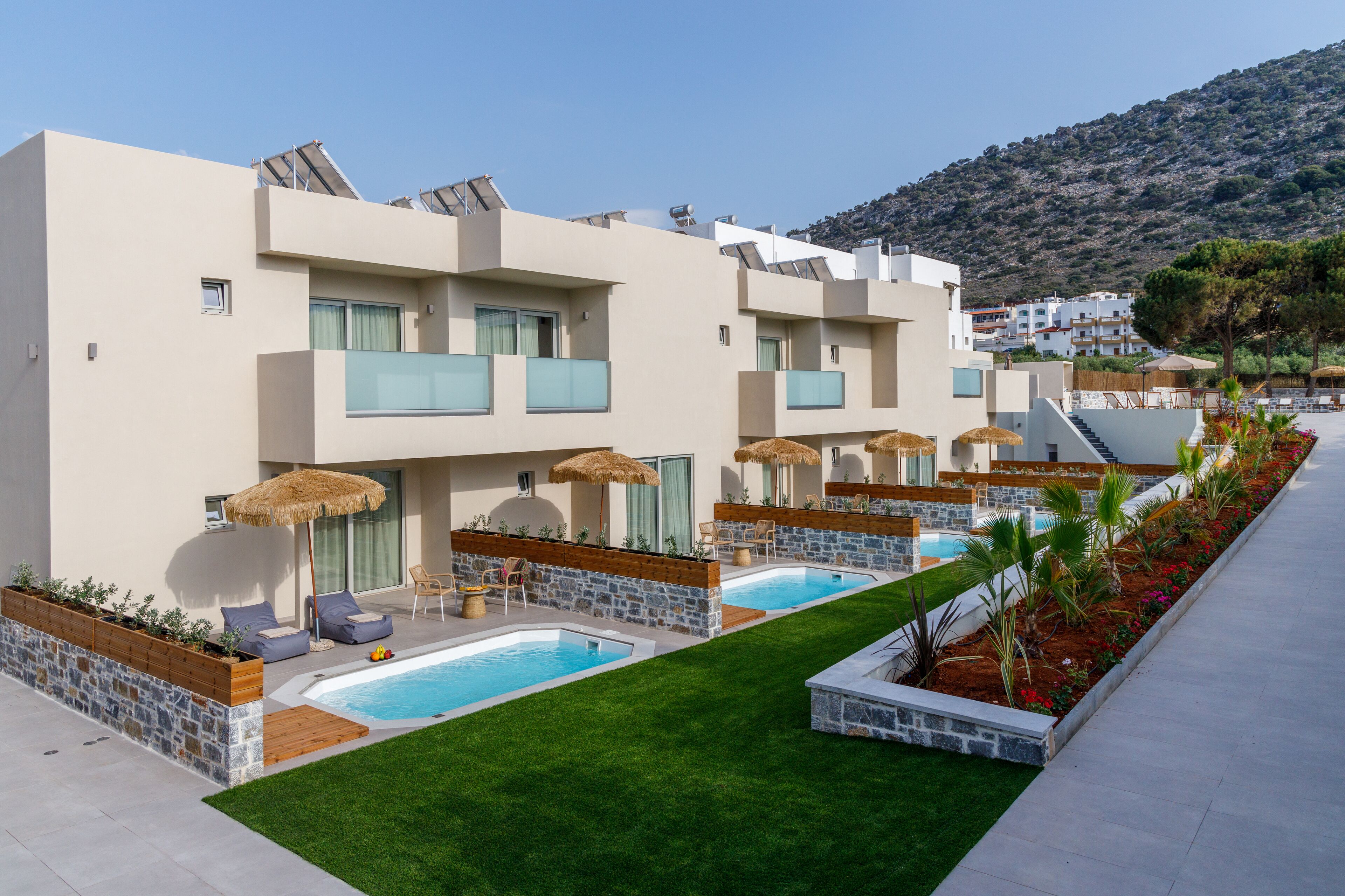 Ein modernes Hotel mit Swimmingpool, Außenbereich und Blick auf eine gebirgige Landschaft.