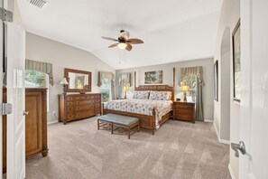 A bedroom with a bed, a bench, a dresser, a nightstand, and a ceiling fan. - Willie’s Place w/Golf Cart, Hot Tub & Dog Friendly (The Villages)