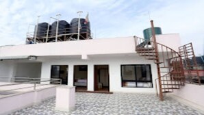 A modern building with a flat roof, a staircase, and a covered outdoor area with a tiled floor. - MeroStay 184 Hotel Sweet Town (Kathmandu)