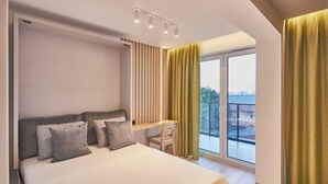 A modern bedroom with a bed, desk, and large window. - Apartamenty Swinoujscie -Matejki 1B (Swinoujscie)