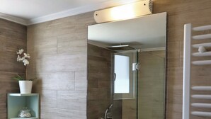 A modern bathroom with a freestanding sink, a mirror, and a towel rack. - Sitia Bay View Villa Apartment (Σητεία)