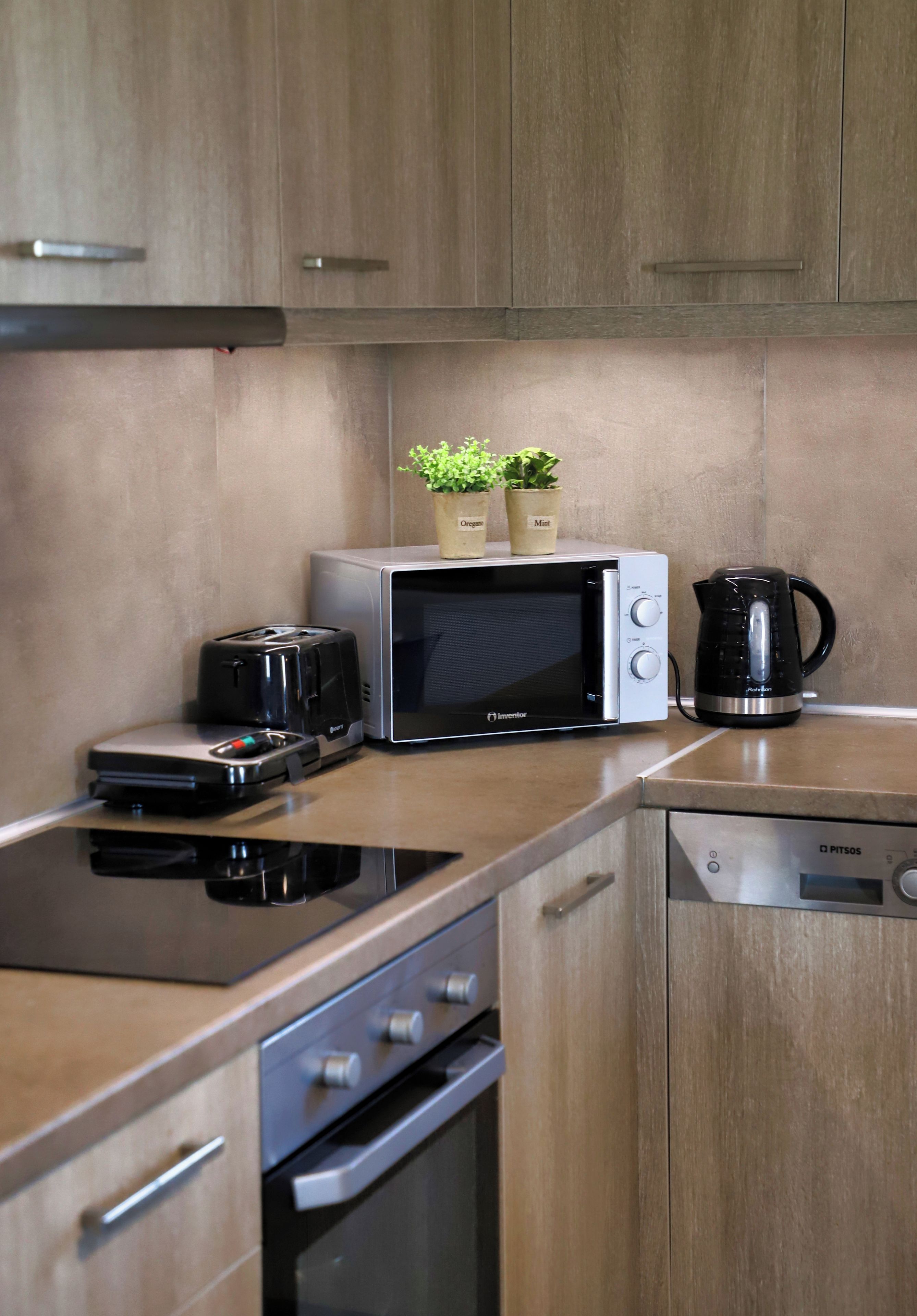 Cozinha equipada com micro-ondas, torradeira, cafeteira e máquina de lavar louça.