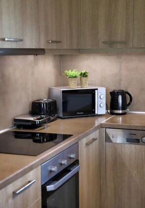 A kitchen with a microwave, toaster, coffee maker, and a dishwasher.