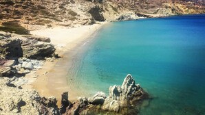 A coastal landscape with a sandy beach, clear blue waters, and rocky terrain. - Sitia Bay View Villa Apartment (Σητεία)