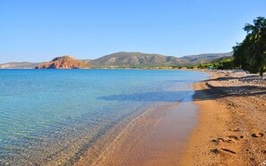 A beach with clear water, pebbly shore, and mountains in the background. - Sitia Bay View Villa Apartment (Σητεία)