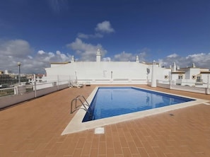 Una piscina en la azotea con vistas despejadas al horizonte de la ciudad.