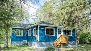 Una casa azul con una escalera de madera y un cartel con el número 332.