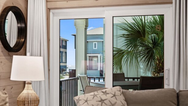 Ein Balkon mit Blick auf Gebäude, einer Topfpflanze und einem Sofa mit Kissen mit Sternenmuster.