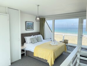 A hotel room with a bed, a bedside table, a chair, a balcony with a view of the beach and ocean. - 26 Piazza - amazing seaviews of Porthmeor Beach (St Ives)