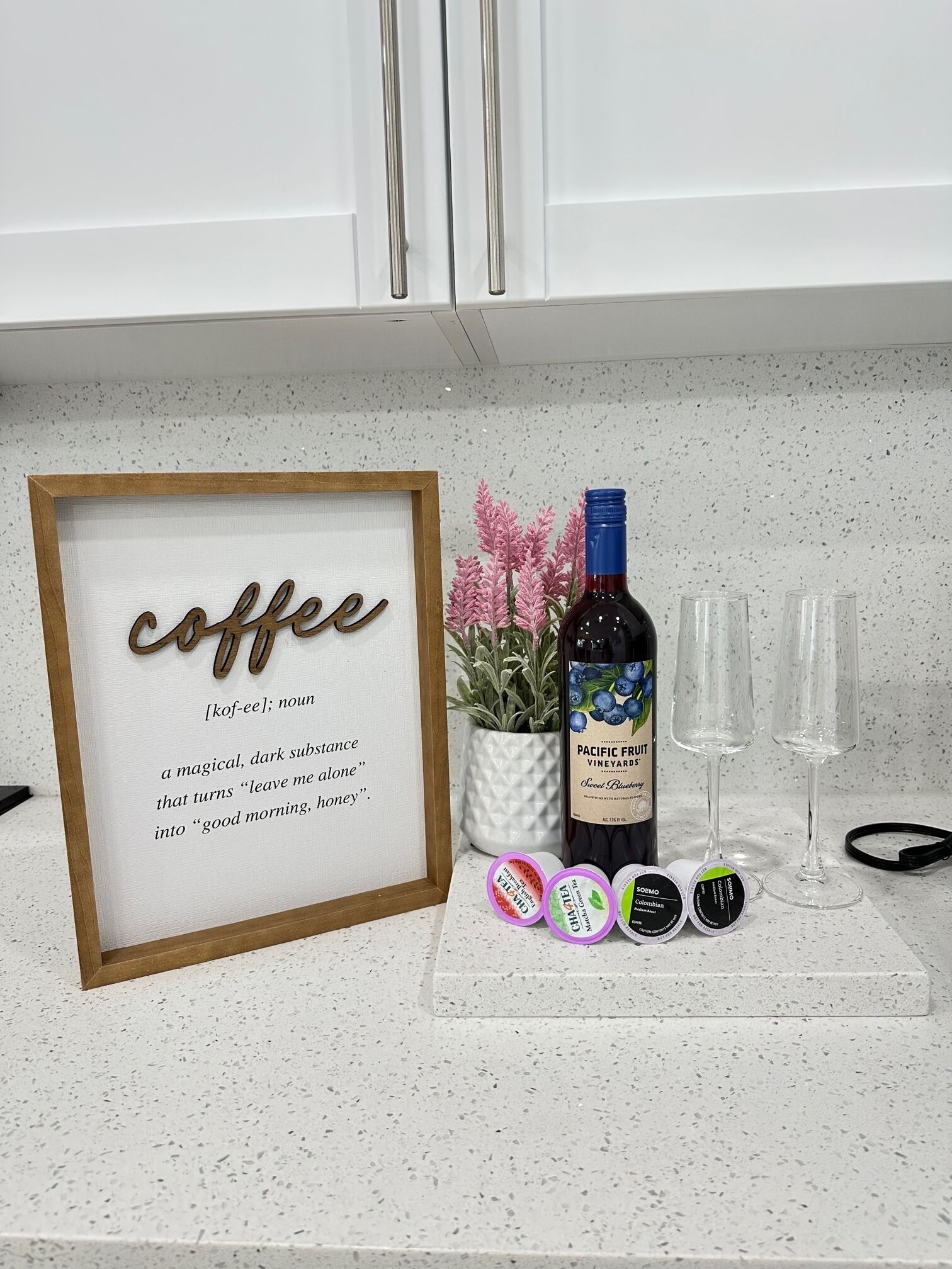 Una encimera de cocina con un cartel enmarcado que dice 