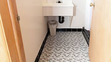 Quarto solteiro básico, 1 cama Queen | Banheiro | Banheira, toalhas de banho, papel higiênico