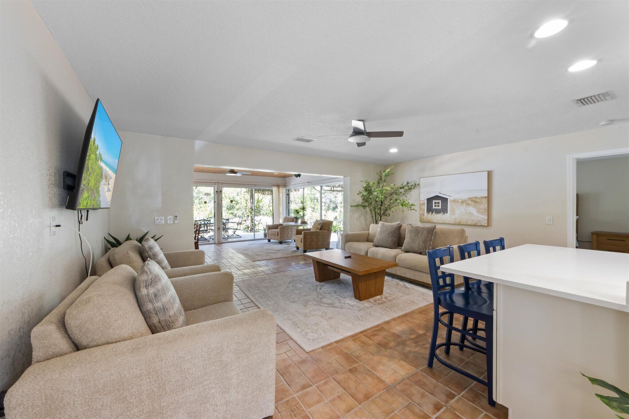 A spacious living room with a sofa set, a coffee table, and a dining area with chairs and a table.