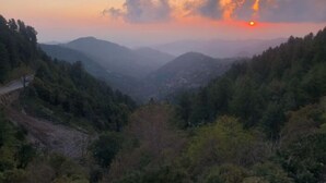 A mountainous landscape with a road winding through the valley. - Paradise View Hotel And Restaurant (Khaira Gali)
