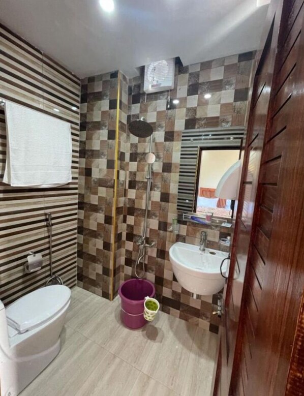 Ein Badezimmer mit Dusche, Toilette und Waschbecken.
