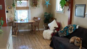 Relax in this inviting living space with a sofa, dining table, and potted plants.