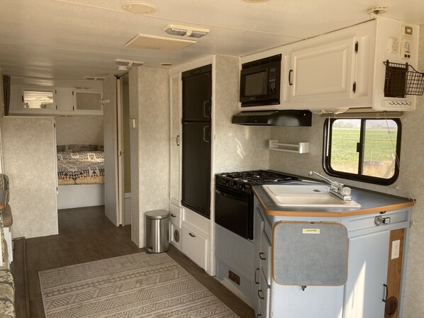 Enjoy a compact kitchen with a stove, microwave, and sink, perfectly organized for a practical stay.