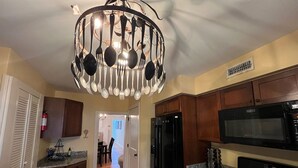 Una cucina con mobili in legno, un frigorifero nero, un forno a microonde e una cucina a gas.
