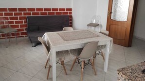 Un espace repas comprenant une table, des chaises, un canapé et une porte.