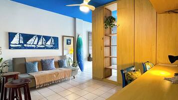 Uma sala de estar moderna com sofá, mesa de centro e área de jantar com mesa de madeira e cadeiras.