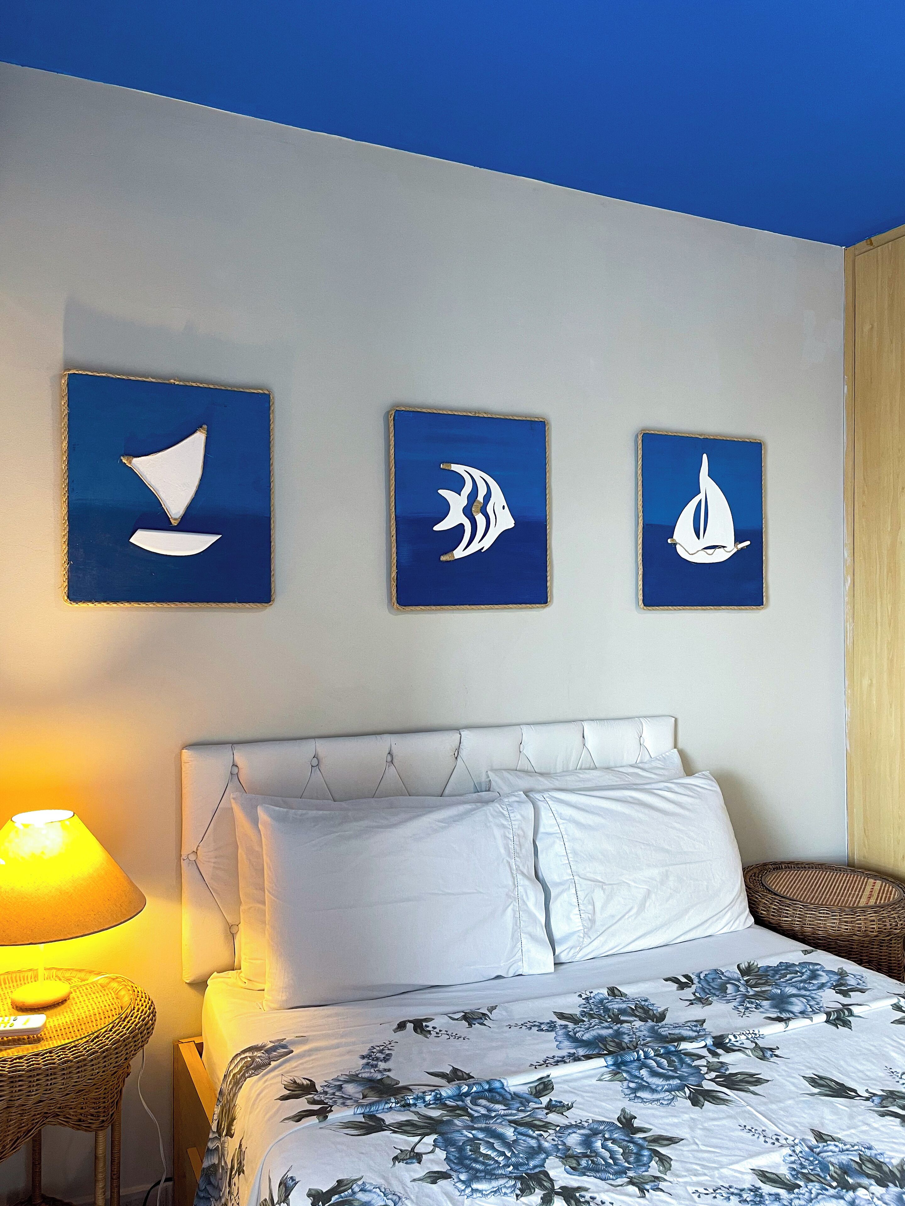 Quarto com uma cama, mesa de cabeceira e abajur.