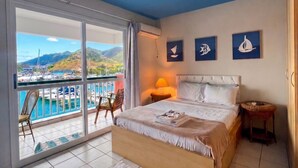 Un dormitorio con cama, vista al puerto deportivo y balcón.
