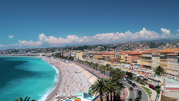 A coastal cityscape with a beach, buildings, and palm trees. - N&J - STUDIO RIVIERA - Central - Very close sea (Niza)