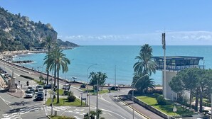 Una carretera costera con vista al mar, palmeras y un edificio que dice 'Port Menton - Garaman'.