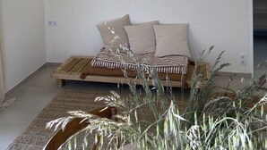 Un dormitorio minimalista con una cama de madera, dos luces fijadas a la pared y un ventanal grande.