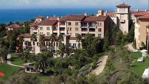 A multi-story hotel with a Mediterranean architectural style, featuring terracotta roof tiles and a central courtyard with palm trees. - Marriott’s Newport Coast - Majestic Views- 2 Bedroom - Full Resort Access (Newport Beach)