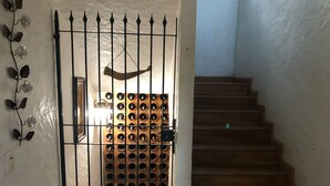 A wooden staircase leading to a room with a wine rack. - Kronemhouse Pousada (Petrópolis)