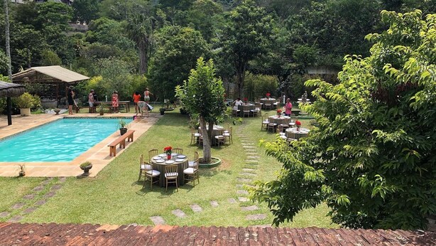A pool area with a wooden deck, surrounded by lush greenery and a mountainous backdrop. - Kronemhouse Pousada (Petrópolis)