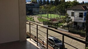 A balcony with a view of a residential area, including houses and a road. - Hotel Charli (Kobuleti)
