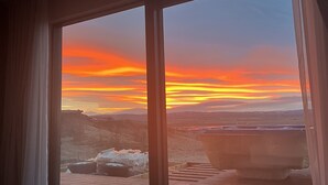 A room with a large window overlooking a sunset over a mountainous landscape. - Spacious villa in Golden Circle with amazing view & hot tub! (Reykholt)