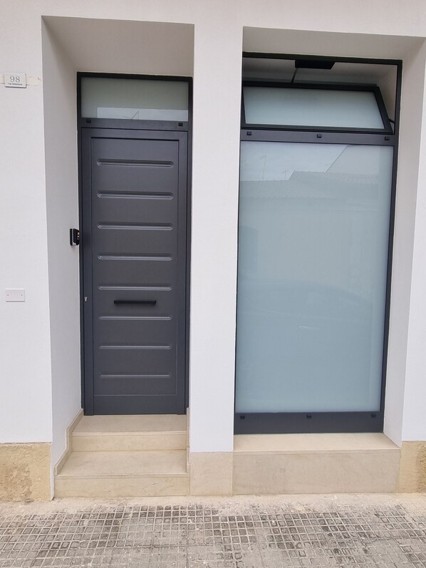 A modern door with a handle and a glass panel above it.
