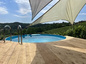 A swimming pool with a wooden deck and metal railings, surrounded by a hillside landscape. - Auszeit vom Alltag- Sanfter Tourismus in Kroatiens Weinbergen (Leštakovec)