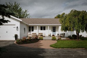 A single-story house with a front porch, a garage, and a well-maintained lawn.