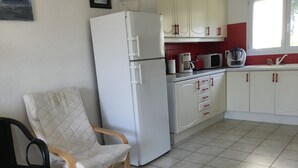 A compact kitchen with white cabinets, a refrigerator, a microwave, and a coffee maker. - Maison Très Bien Située,dans Quartier Résidentiel.endroit Très Calme ,près Océan (Biscarrosse plage)