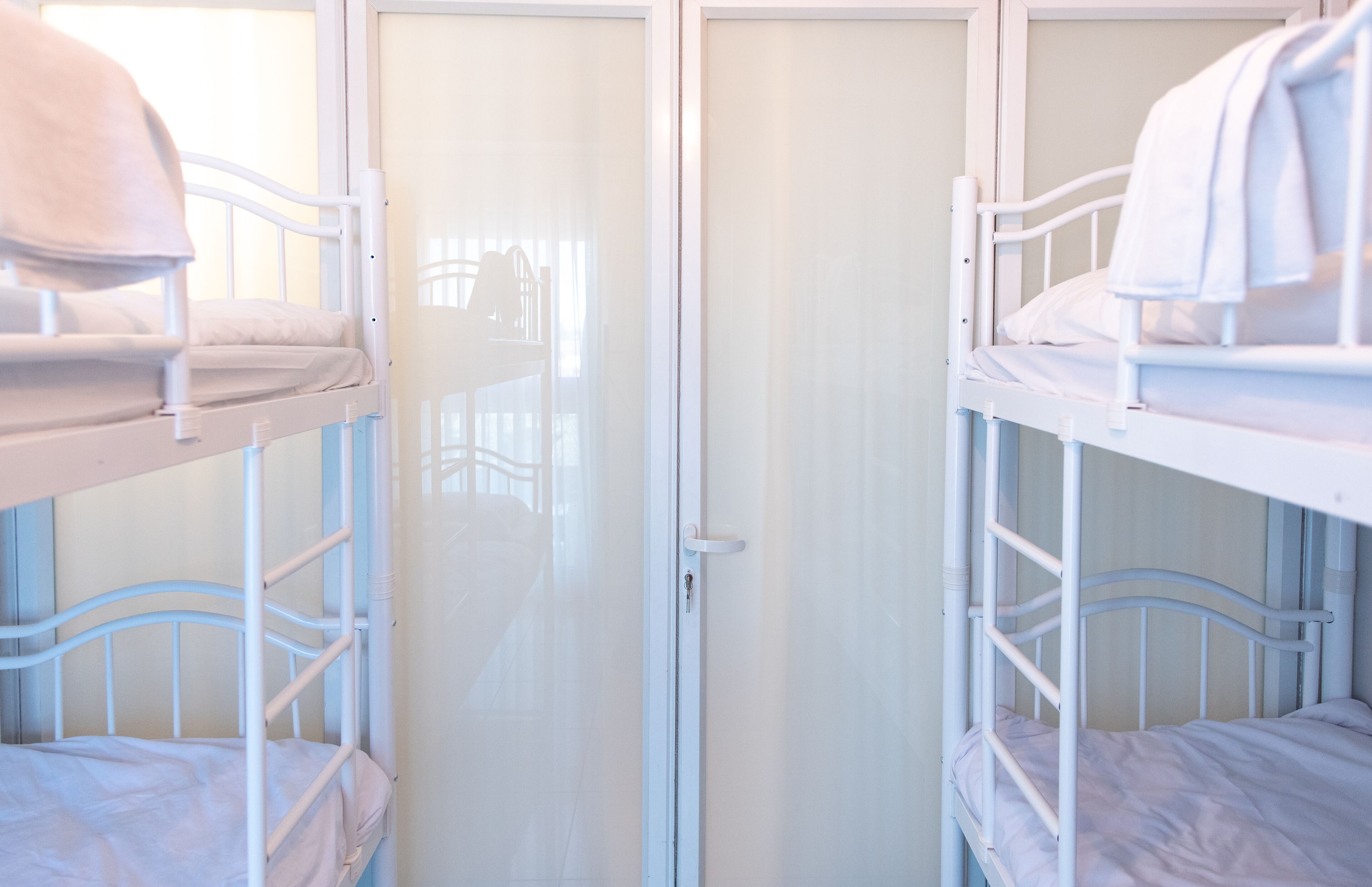 Habitació amb lliteres, una porta corredissa i una finestra.