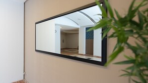 A mirror reflecting a bathroom with a marble floor, a sink, and a towel rack. - Mahane Yehuda Market Apartment Jerusalem (Jerusalem)