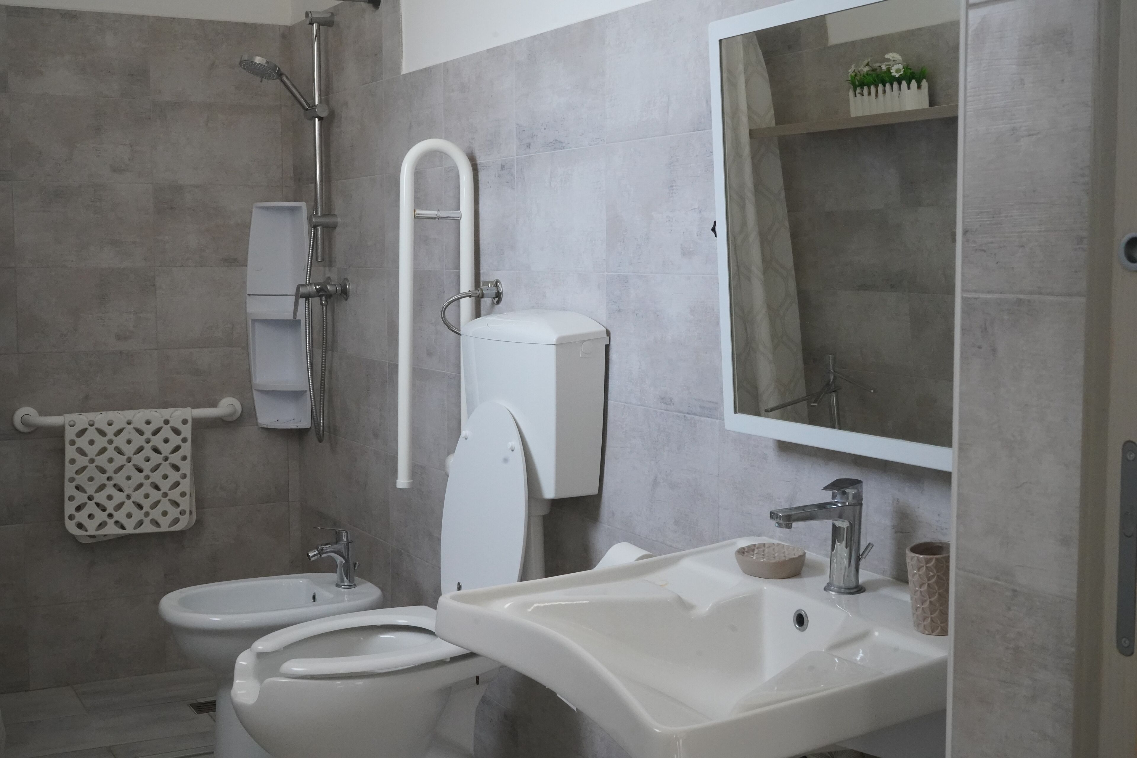 A modern bathroom with a toilet, bidet, and sink.