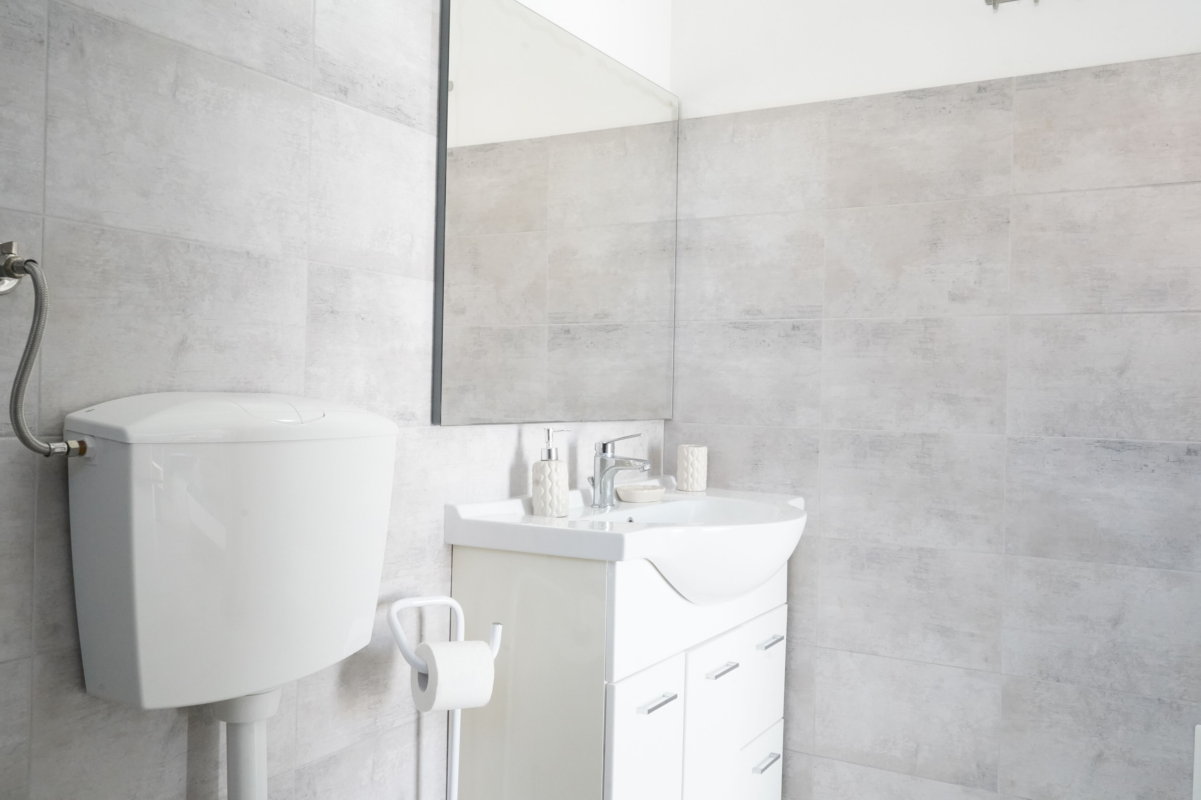 Une salle de bain moderne avec des toilettes, un lavabo et un miroir.