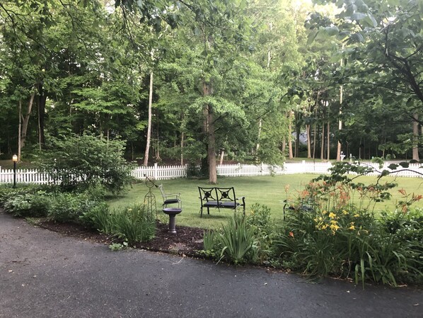 A park with a white picket fence, a bench, and a lamp post.