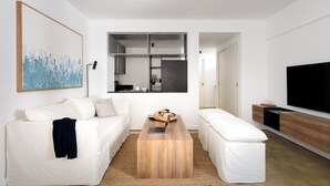Una sala de estar moderna con un sofá, una mesa de centro y un televisor.