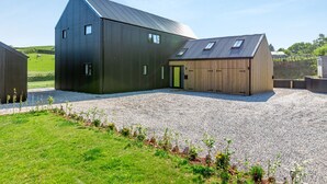 A modern building with a large barn-like structure, a smaller wooden building, and a gravel driveway. - 5 bedroom accommodation in Marldon, near Paignton (Marldon, near Paignton)