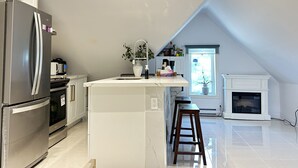 A modern kitchen with a central island, a built-in oven, and a refrigerator. - Cozy 2-Bedroom Apartment In Historical Building.  (Grimsby)